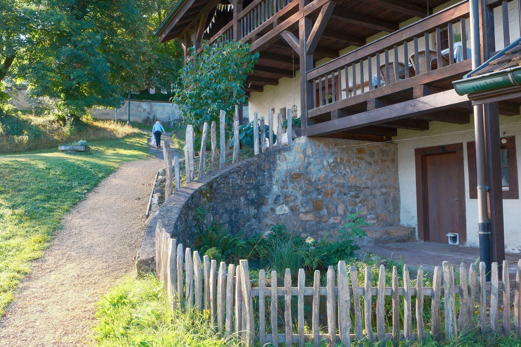A timber picket fence and wooden balcony on a house, showing outdoor woodwork.